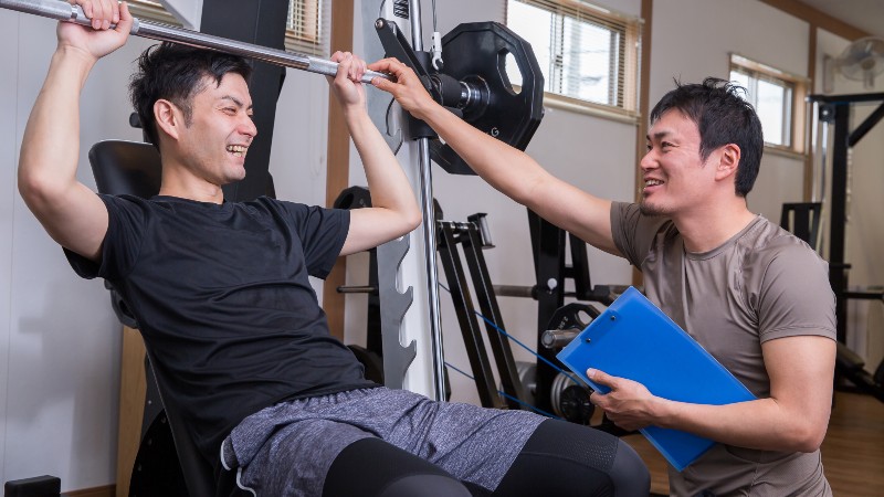 トレーナーのアドバイスをもらう男性